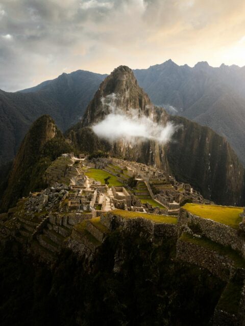 Things To Do in Cusco: Aerial view of the ancient Incan city of Machu Picchu surrounded by mountains.