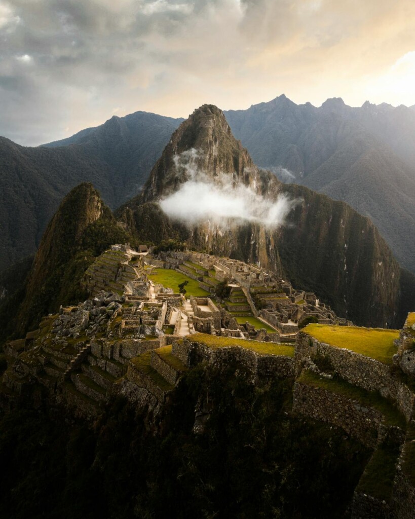 Things To Do in Cusco: Aerial view of the ancient Incan city of Machu Picchu surrounded by mountains.