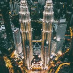 Kuala Lumpur travel guide: The Petronas Twin Towers illuminated at night, standing tall as a modern architectural marvel and symbol of Malaysia.