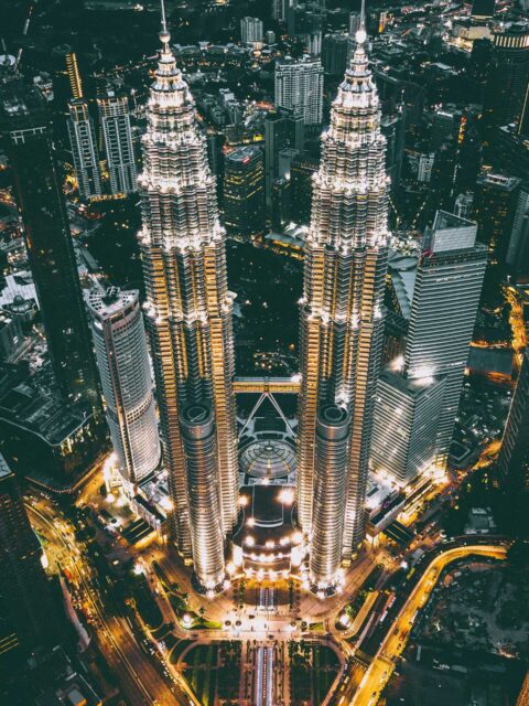 Kuala Lumpur travel guide: The Petronas Twin Towers illuminated at night, standing tall as a modern architectural marvel and symbol of Malaysia.