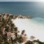 Things to Do in Tulum: Beach view in Tulum with turquoise water and palm trees.