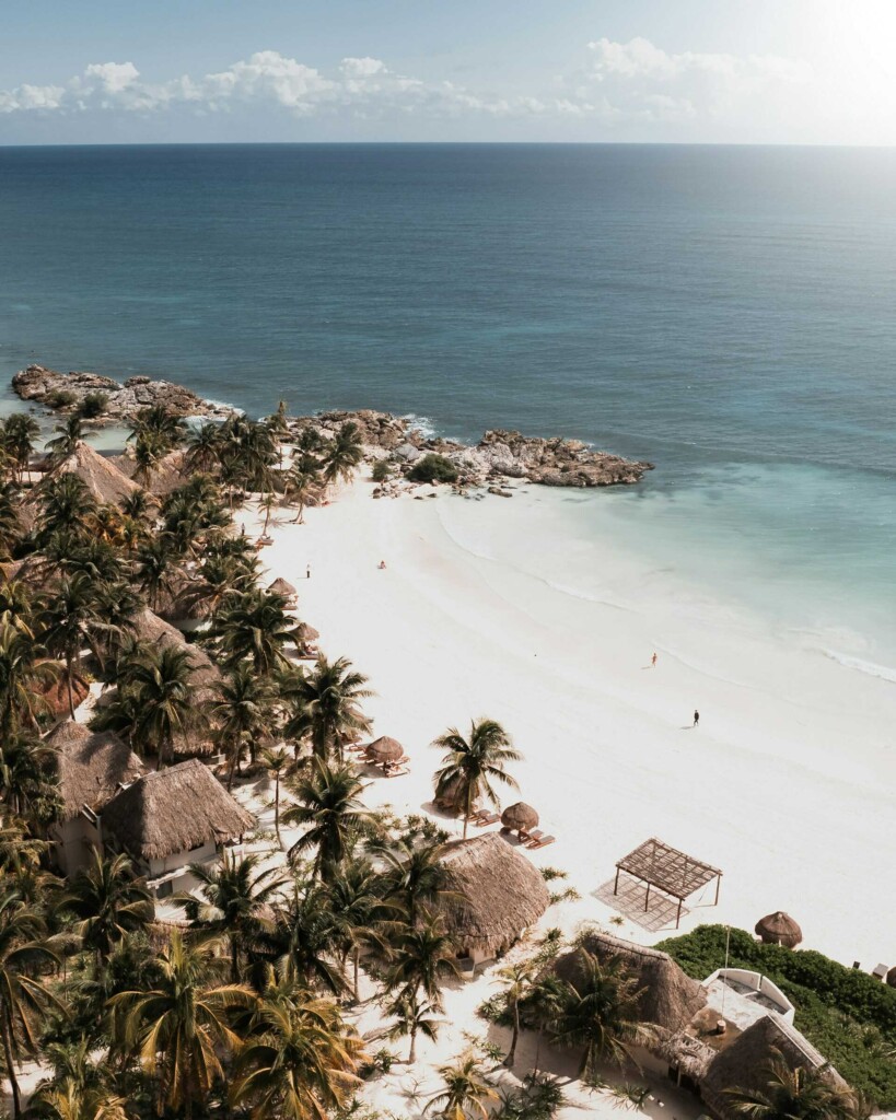 Things to Do in Tulum: Beach view in Tulum with turquoise water and palm trees.