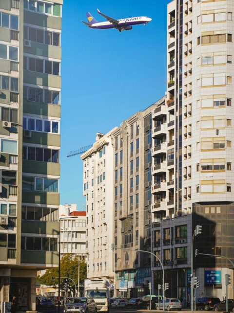 Portugal Travel Essentials: street view in Lisbon with high-rise buildings and an airplane overhead